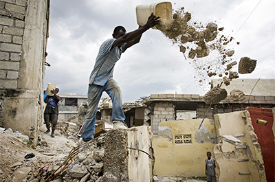 Des habitants de Port-au-Prince (Haïti) dégagent les gravats, suite au tremblement de terre de janvier 2010 La mission de l'Onu, la Minustah, aide à dégager les routes. ©Photo ONU/Marco Dormino
